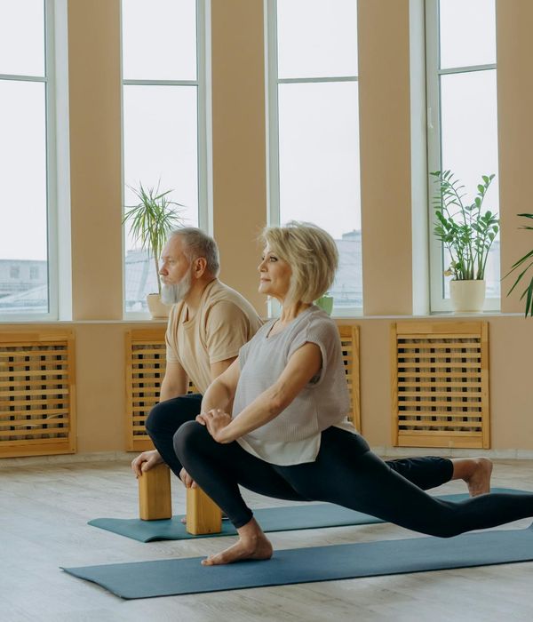 Woman performing a gentle back-stretching yoga pose in a calm environment.